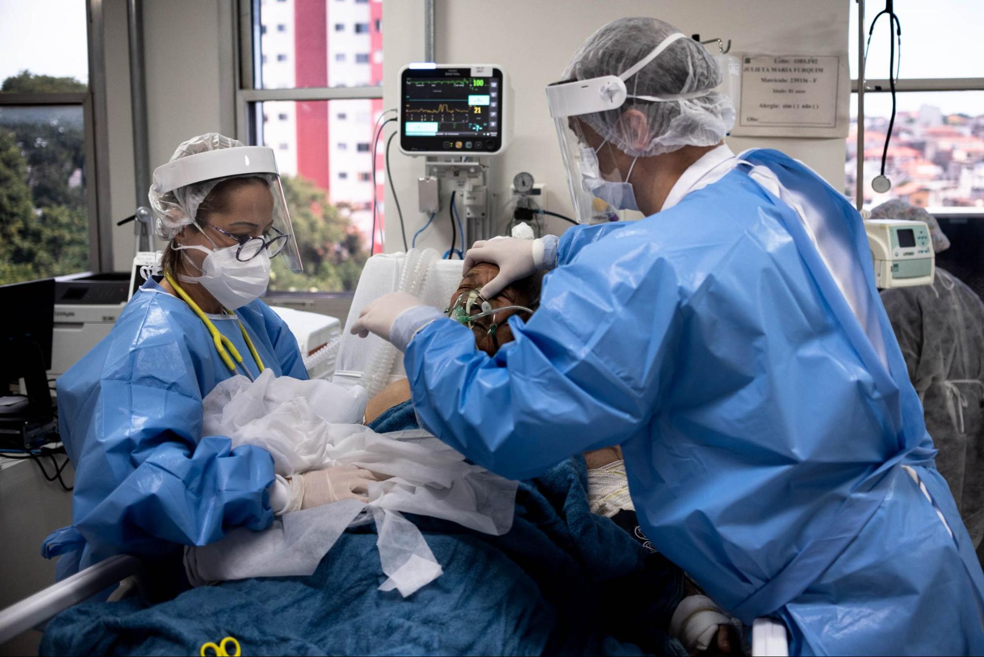 Hospital staff help a patient with oxygen